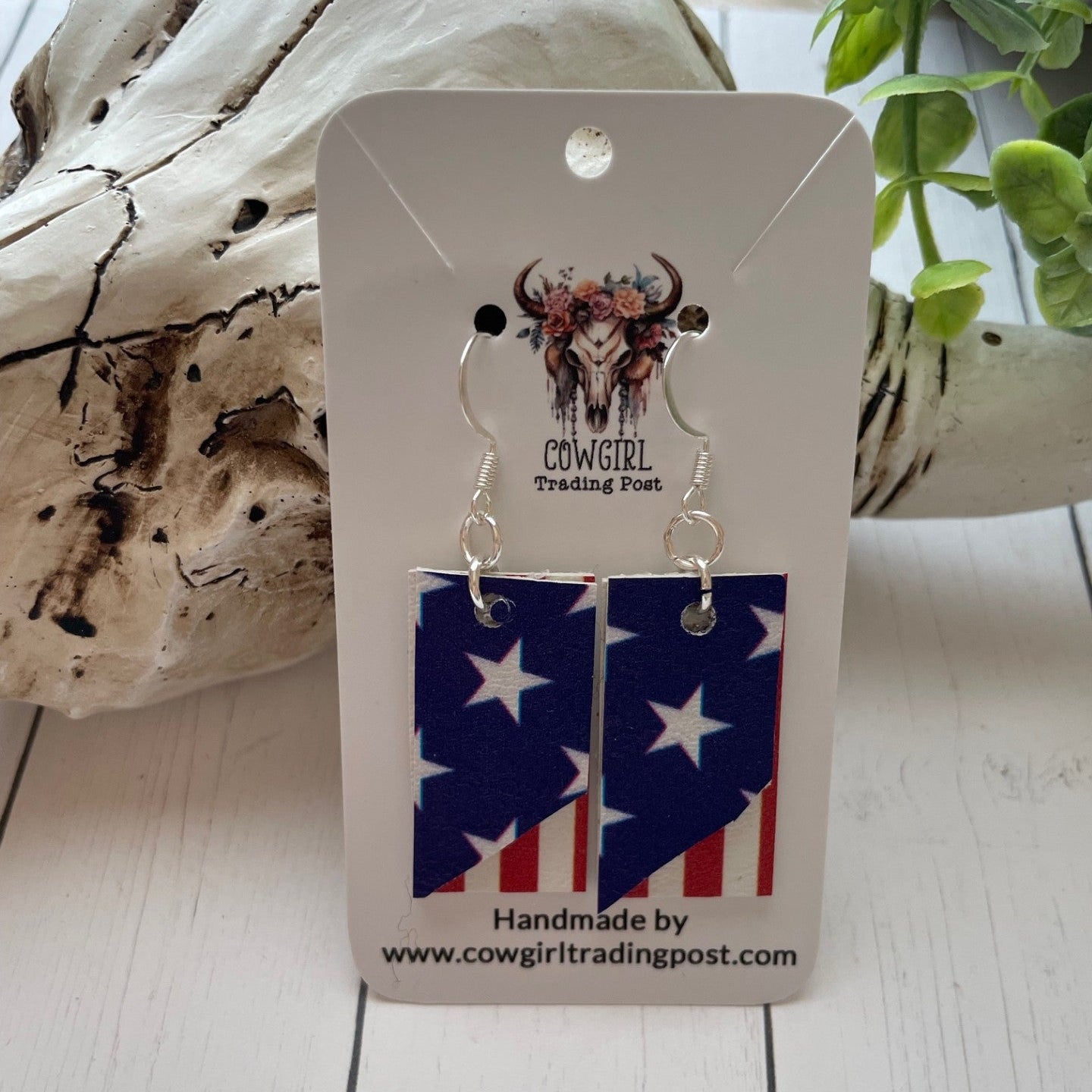 Pair of earrings on a 'Cowgirl Trading Post' card with a wooden background