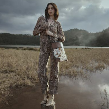Person standing in a field with a stormy sky