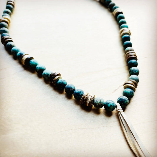 Beaded necklace with tassel on a light wooden surface