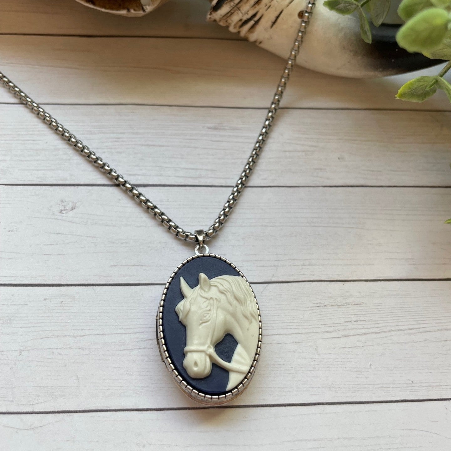 Necklace with a horse pendant on a wooden surface