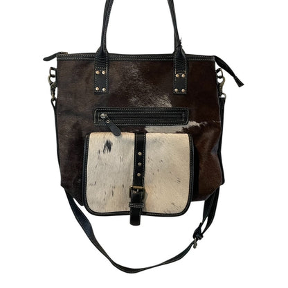 Brown leather handbag with a contrasting white section on a white background