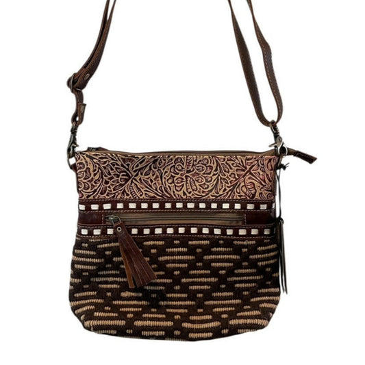 Brown patterned handbag with a strap on a white background