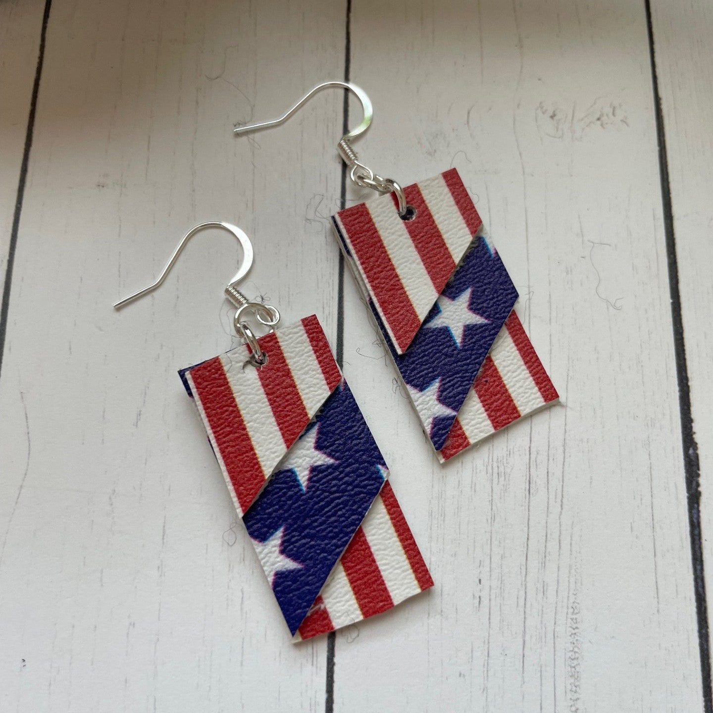 American flag patterned earrings on a wooden surface