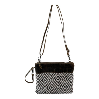 Crossbody bag with black and white patterned pouch on a white background