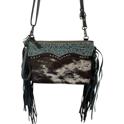 Black and white cowhide with tooled turquoise leather and black fringe on the side purse