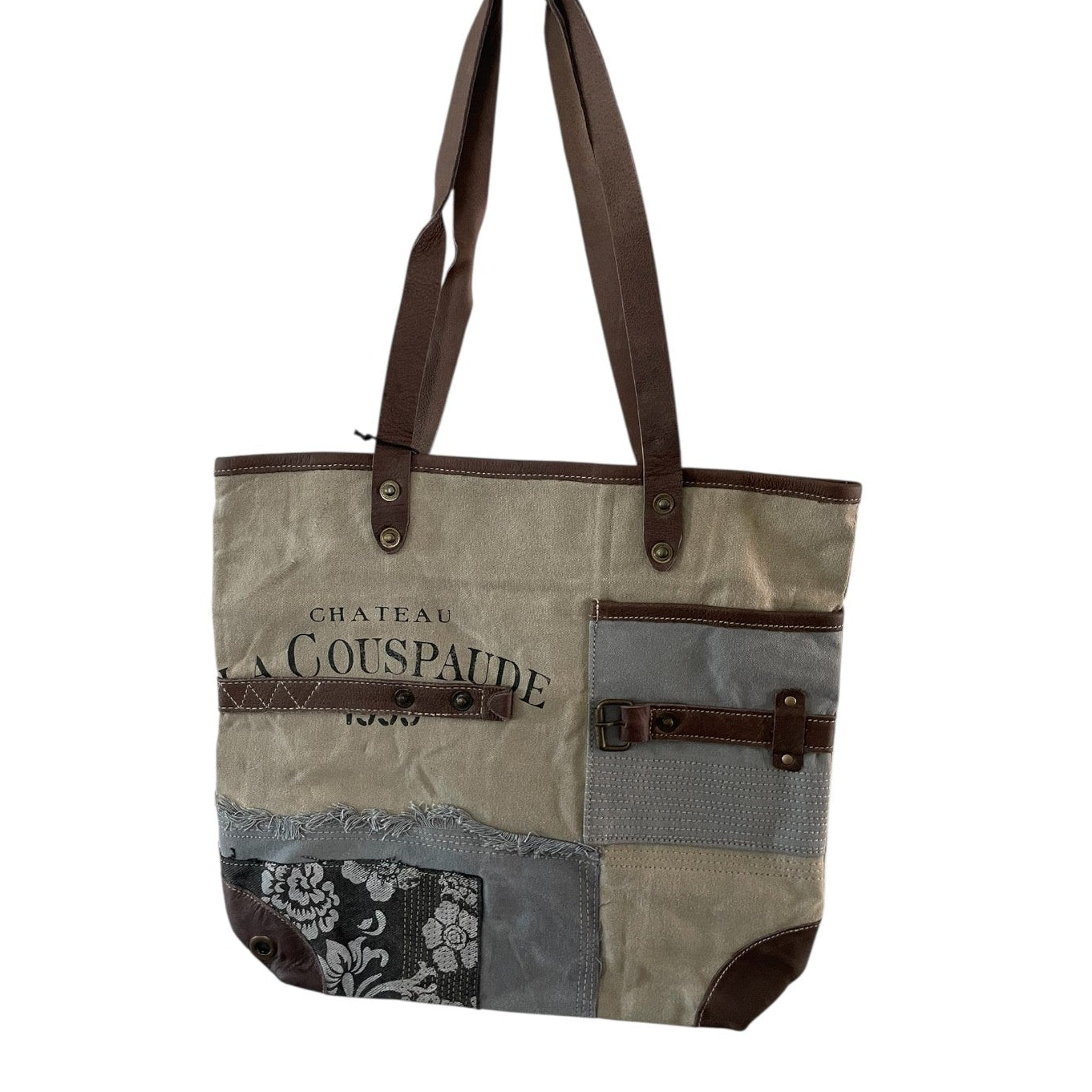 Patchwork tote bag with brown handles and visible branding on a white background