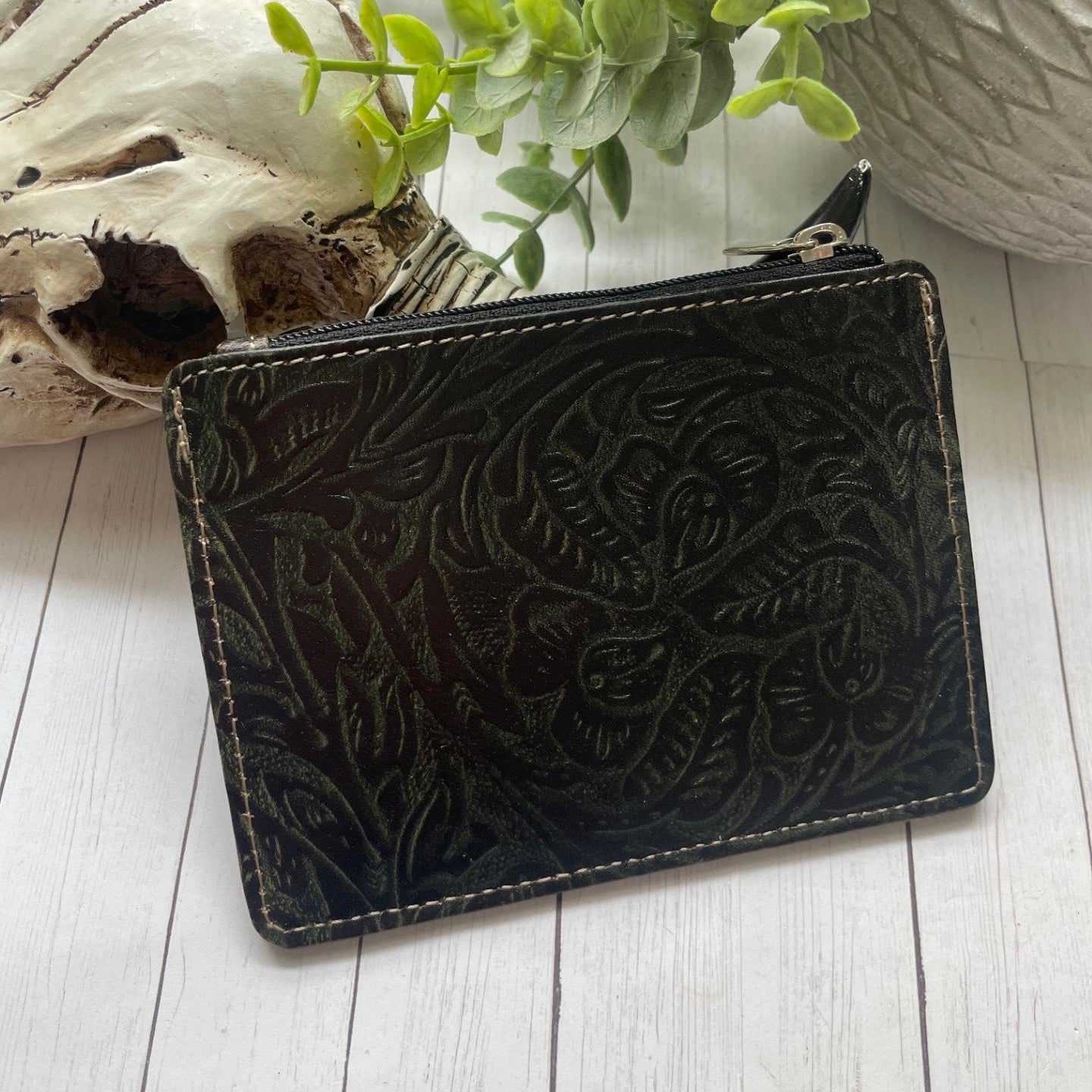 Black and white cowhide and leather wallet with a snap closure and credit card slots