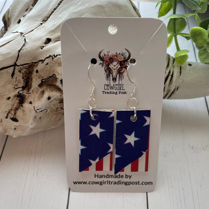 Pair of earrings on a 'Cowgirl Trading Post' card with a wooden background