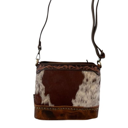Brown leather crossbody bag with cowhide pattern on a white background