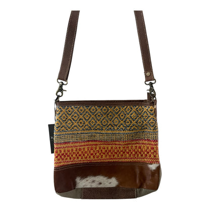 Brown crossbody bag with patterned flap and leather accents on a white background