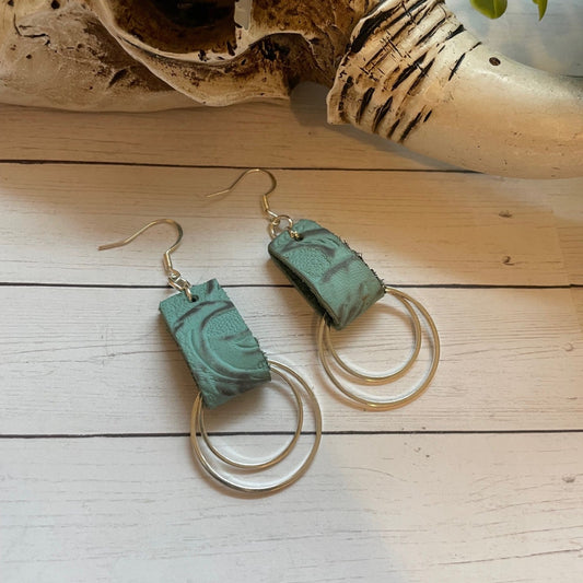 Turquoise earrings with silver loops on a wooden surface