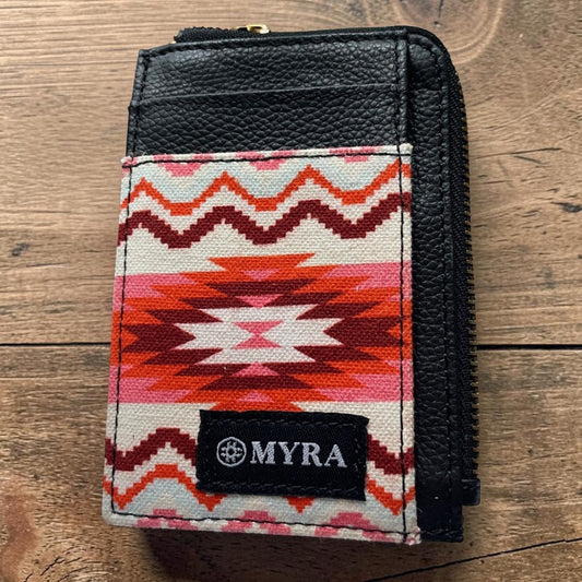 Small wallet with a colorful pattern and 'MYRA' brand logo on a wooden surface