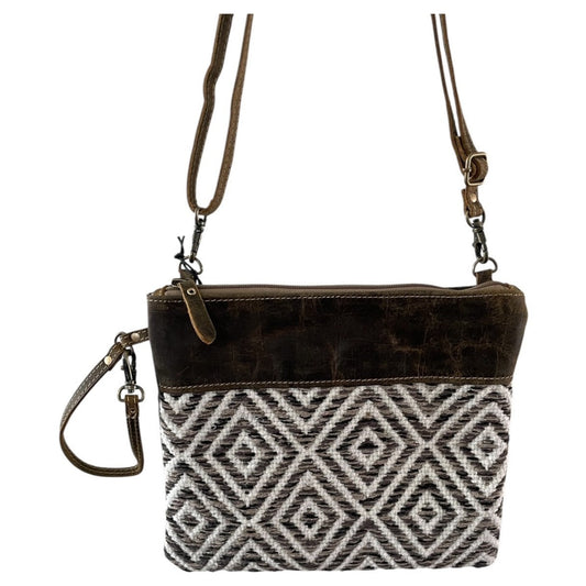Brown leather crossbody bag with geometric pattern on a white background