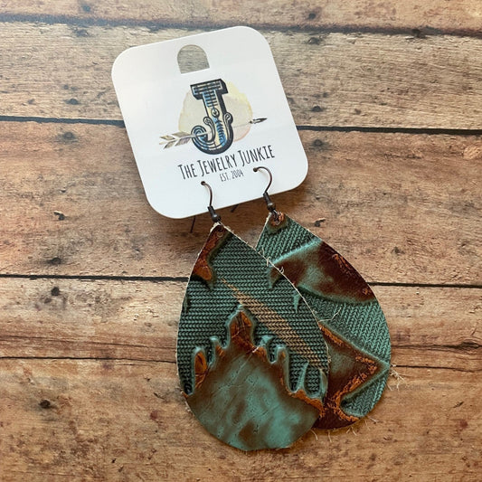 Green and brown patterned earrings on a wooden surface with 'The Jewelry Junkie' card.