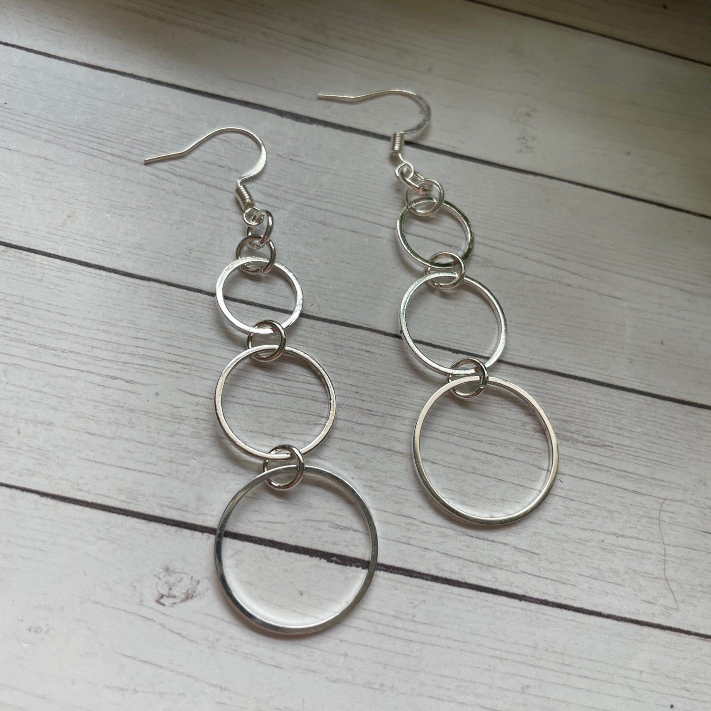 Silver hoop earrings on a wooden surface