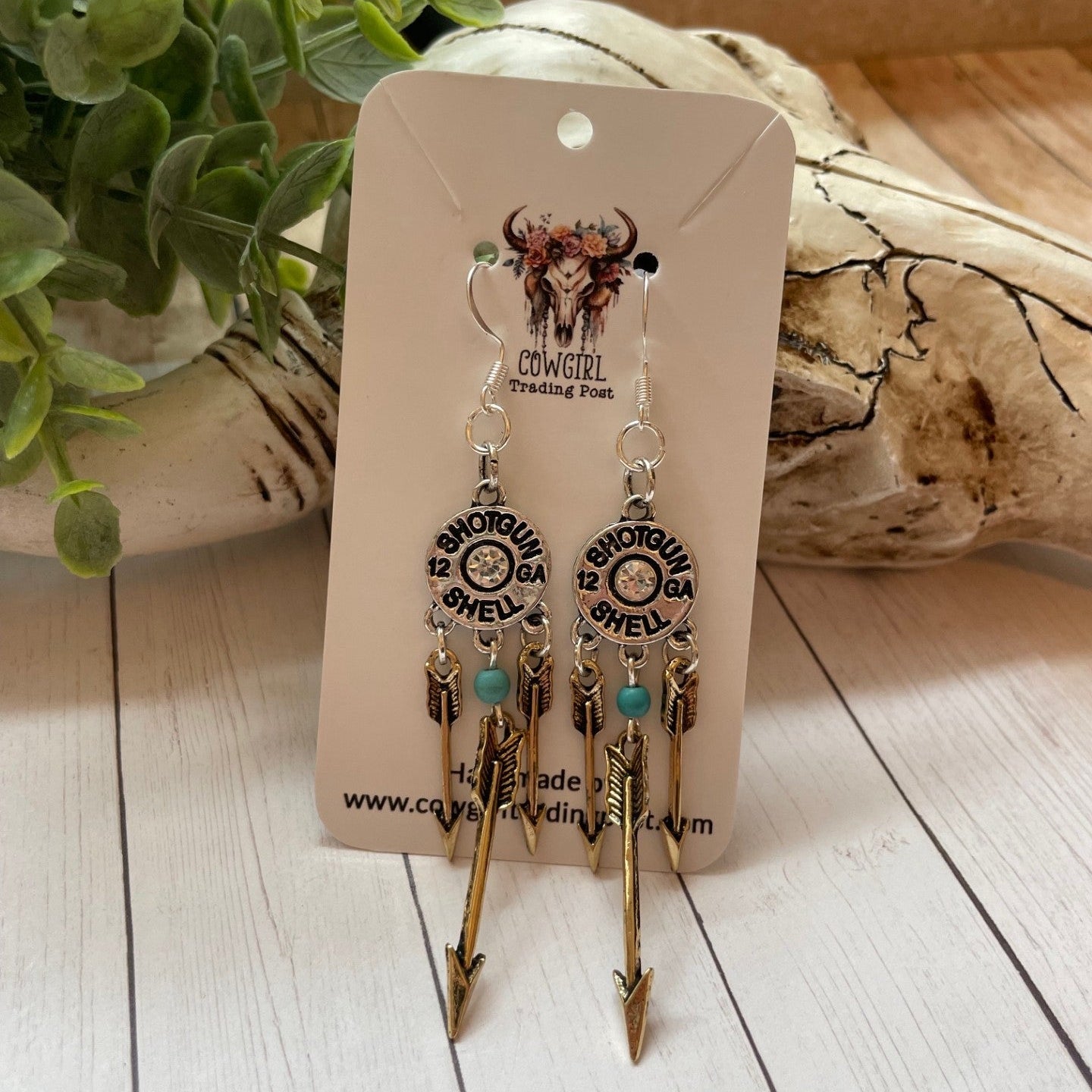 Pair of earrings on a branded card with a natural background