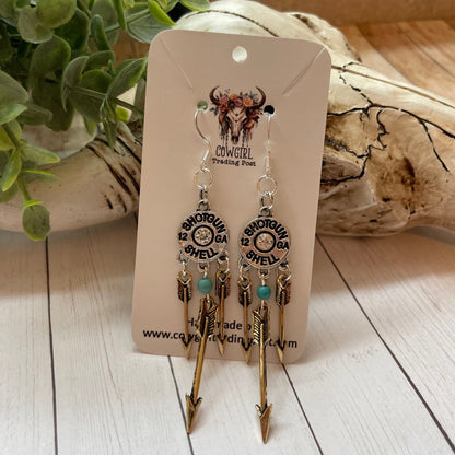 Pair of earrings on a branded card with a natural background