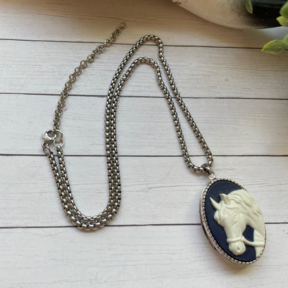 Necklace with a pendant featuring a horse design on a wooden surface.
