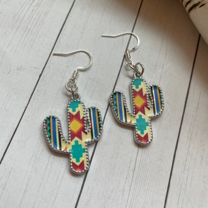 Colorful cactus-shaped earrings on a wooden surface