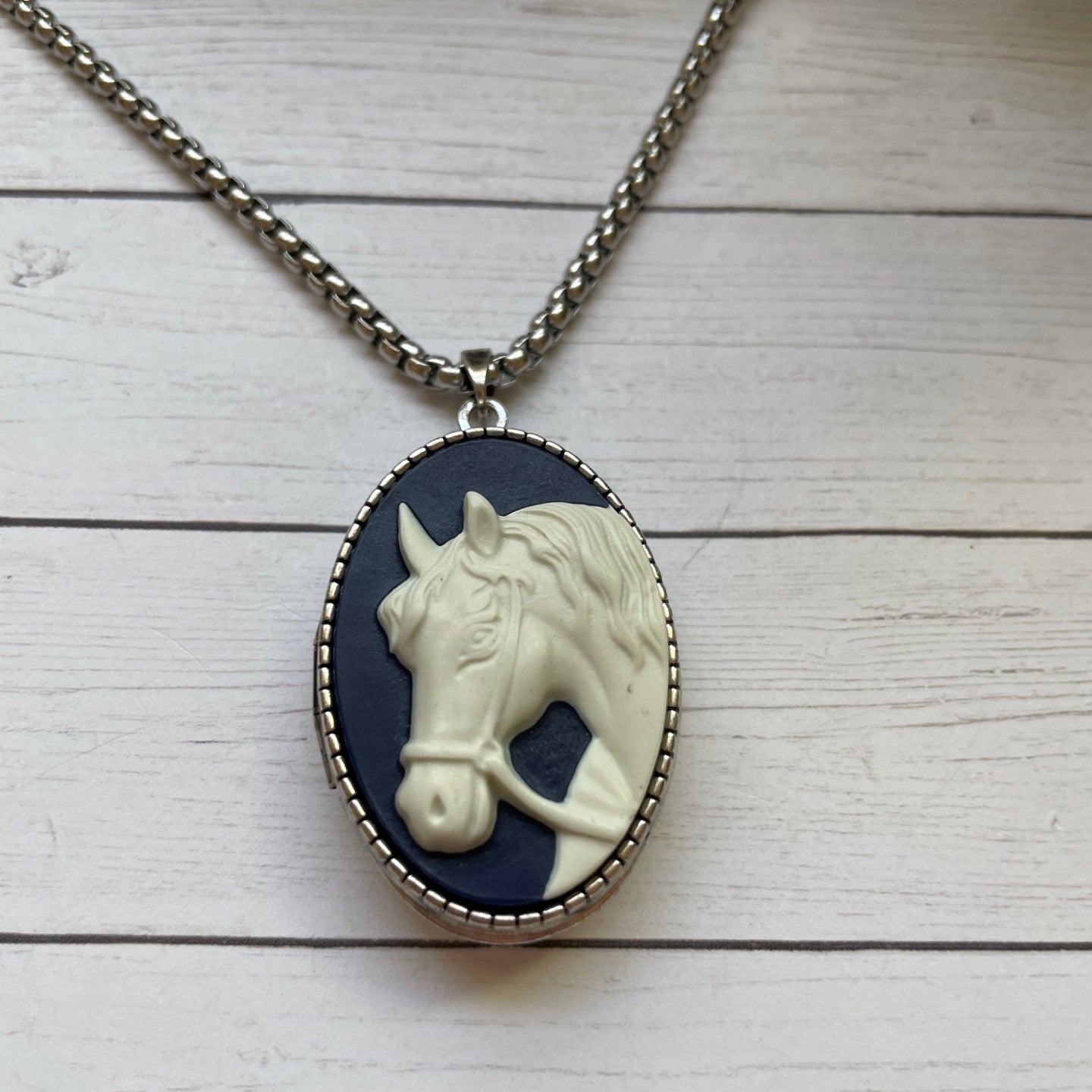 Necklace with a horse pendant on a wooden surface