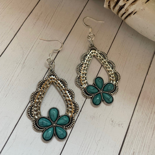 Silver etched teardrop earrings with Turquoise colored stones in a flower shape.