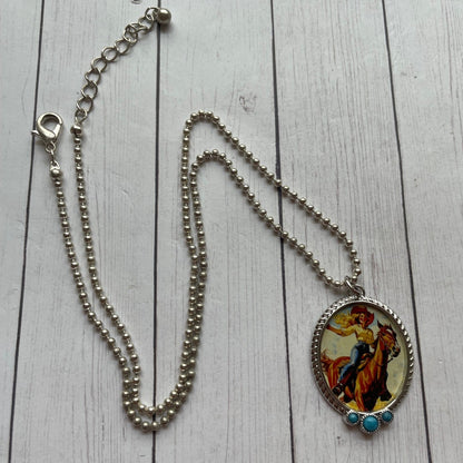 Necklace with a colorful horse and rider pendant on a wooden surface