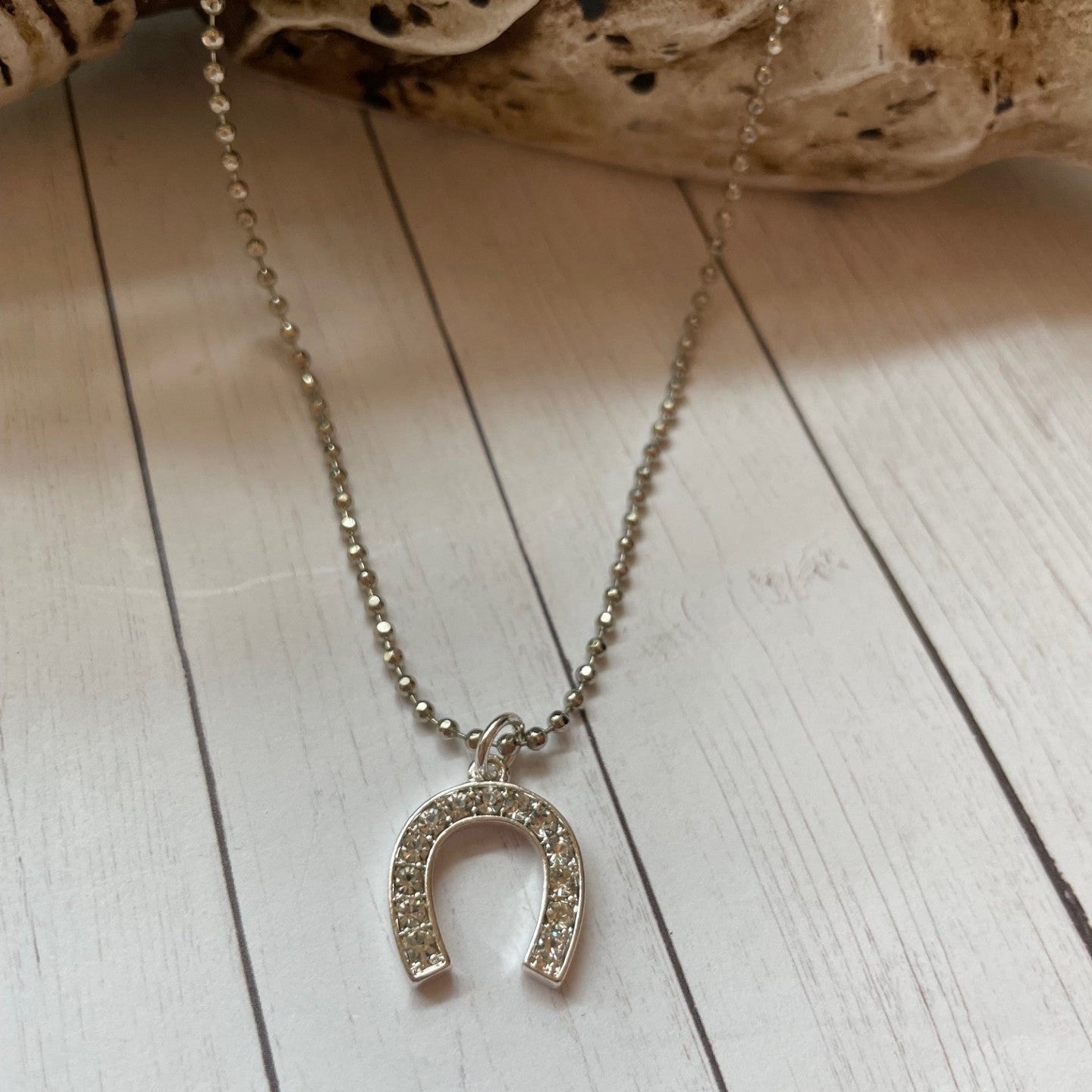 Necklace with a horseshoe pendant on a wooden surface