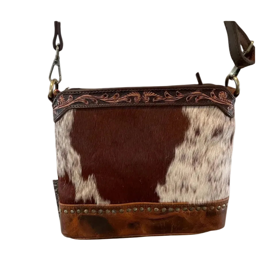 Brown and white cowhide leather bag with decorative stitching on a white background