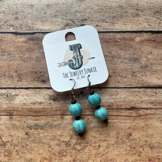 turquoise melon shaped bead earrings on a wood background