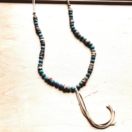 Necklace with blue beads and a large hook on a light wooden surface