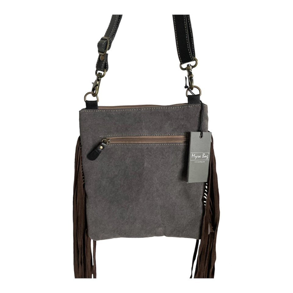 Gray crossbody bag with fringes and a tag on a white background