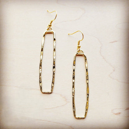 Gold hoop earrings on a light marble background