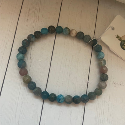 Multicolored beaded bracelet on a white wooden surface