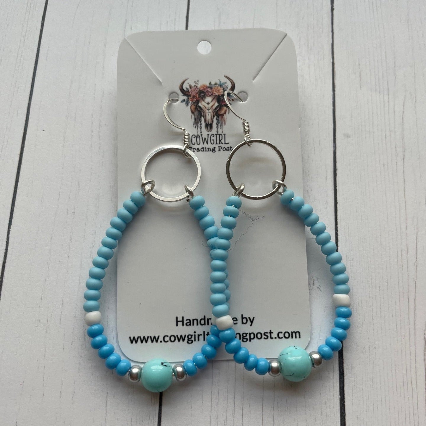 Turquoise beaded keychains on a white card with branding text.