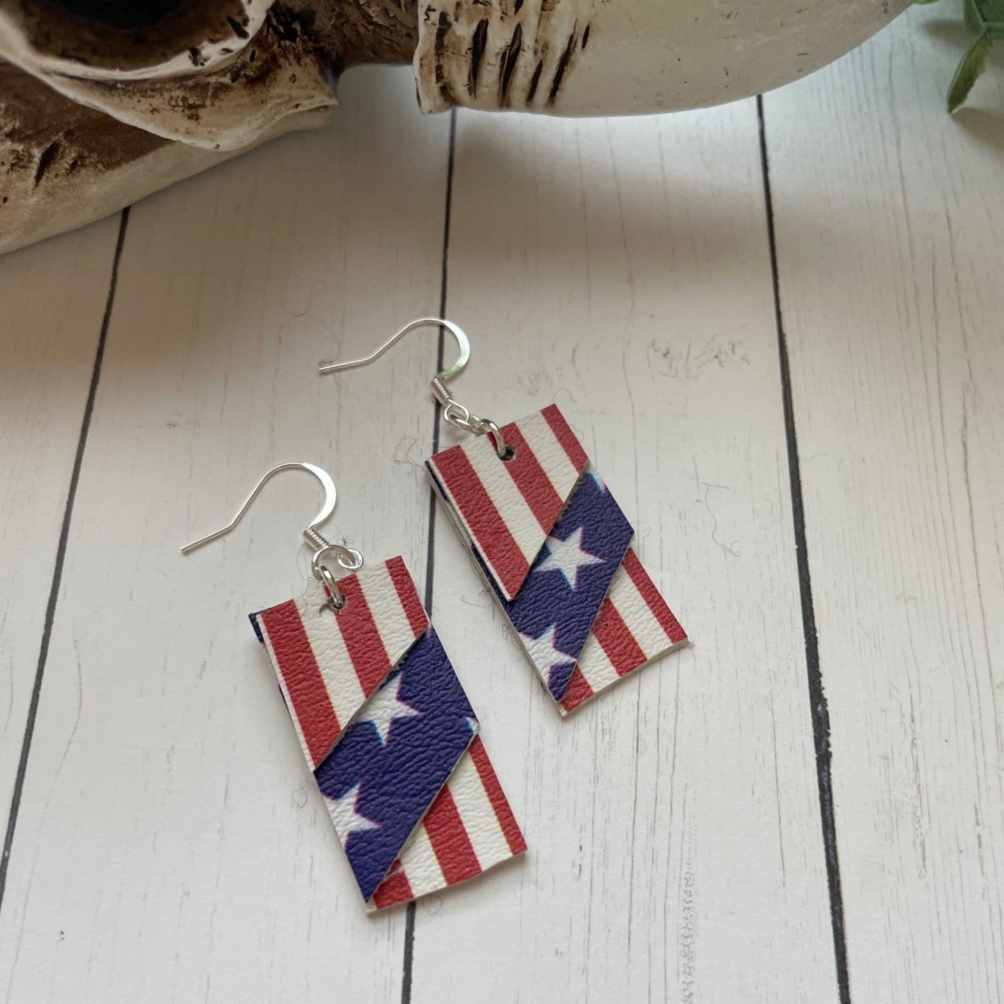 American flag patterned earrings on a wooden surface