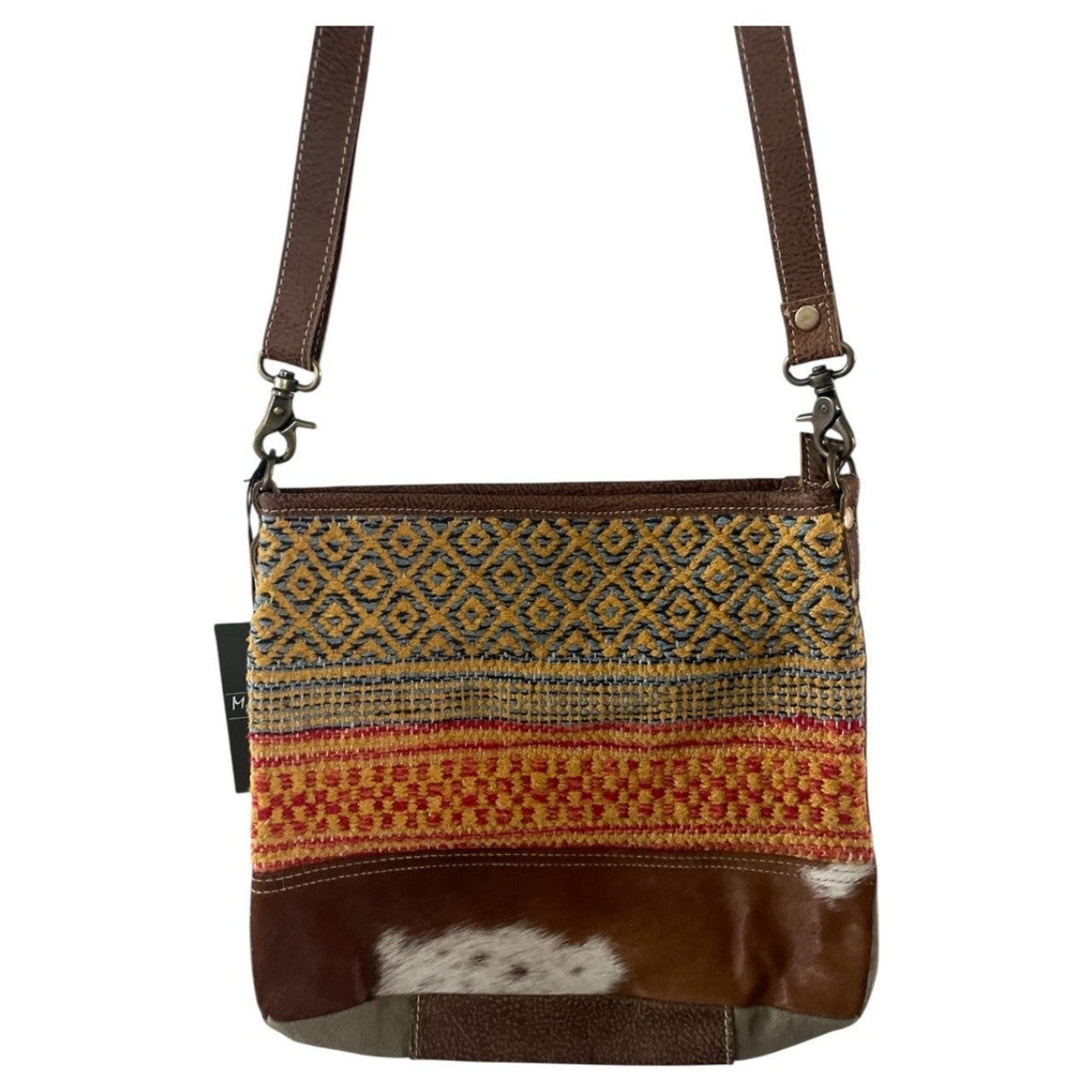 Crossbody bag with patterned fabric and brown leather accents on a white background
