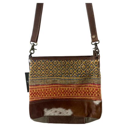 Crossbody bag with patterned fabric and brown leather accents on a white background