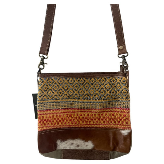 Crossbody bag with patterned fabric and brown leather accents on a white background
