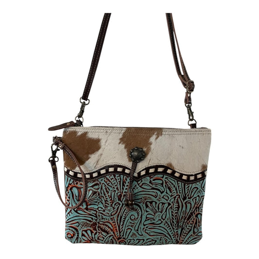 Multicolored patterned handbag with brown leather straps on a white background