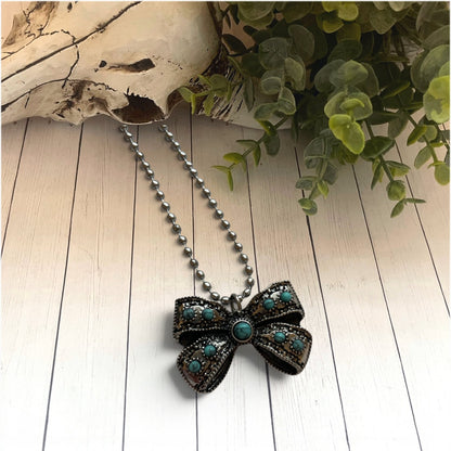 bow style necklace with turquoise bead stones on a ball and chain necklace on a white background