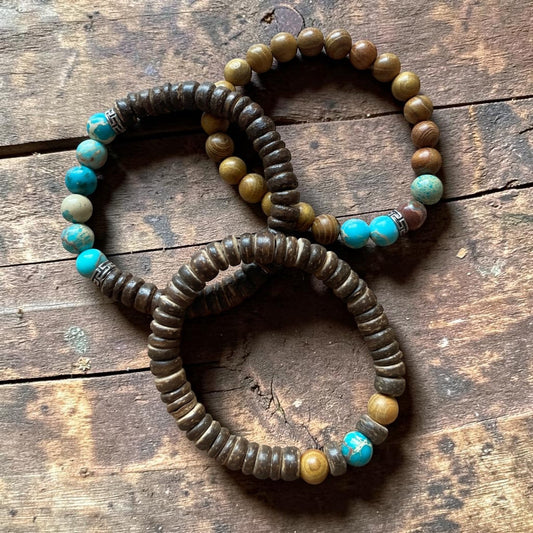 Three beaded bracelets with turquoise and brown beads on a wooden surface