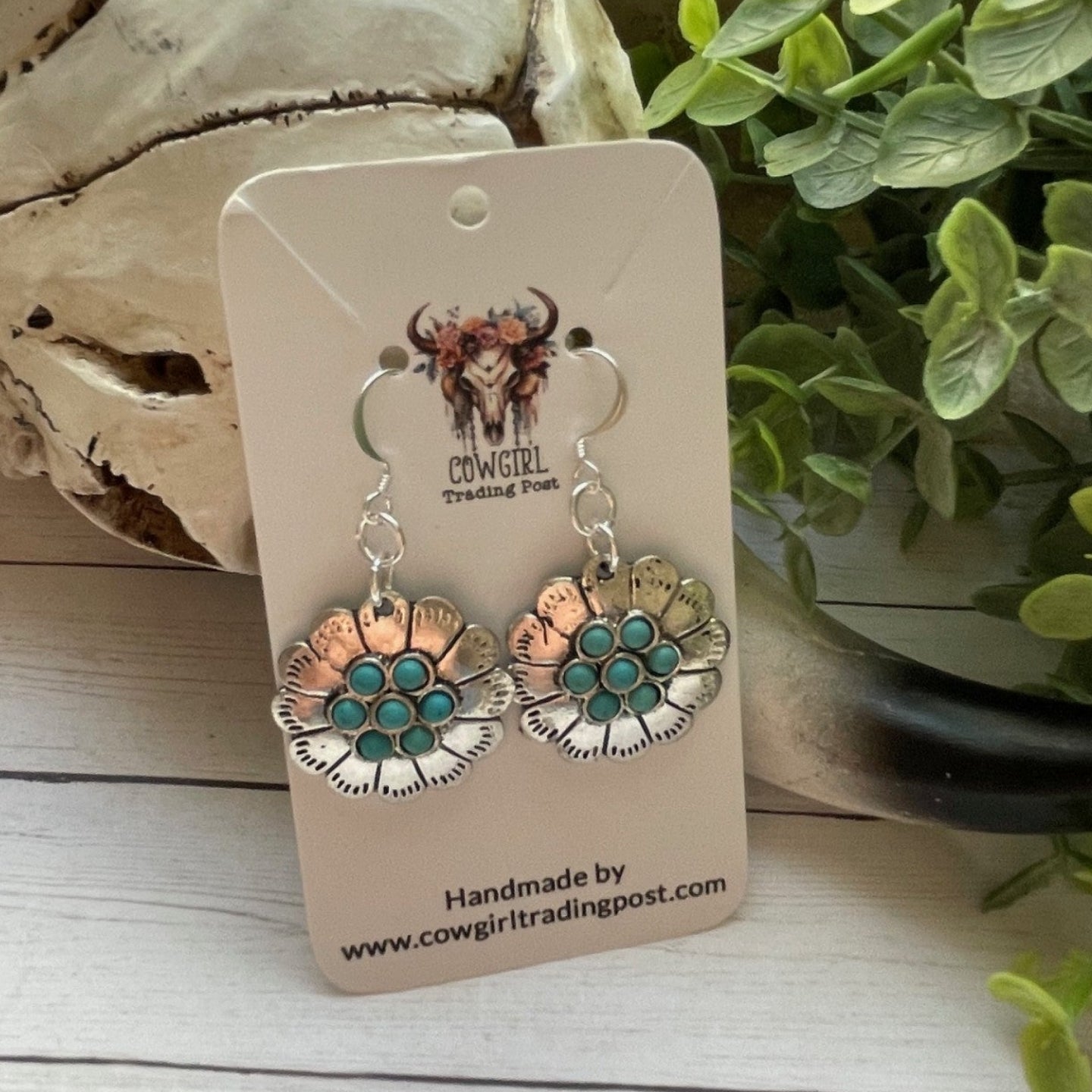 Pair of earrings on a 'Cowgirl Trading Post' card with decorative background