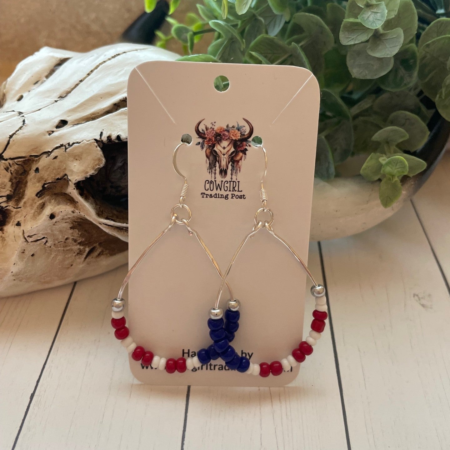 Pair of earrings on a 'Cowgirl Trading Post' card with a natural background