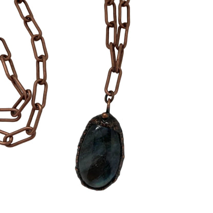 Necklace with a dark stone pendant on a white background