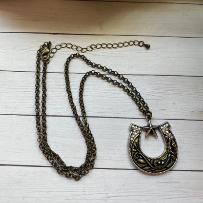 Necklace with a detailed pendant on a wooden surface