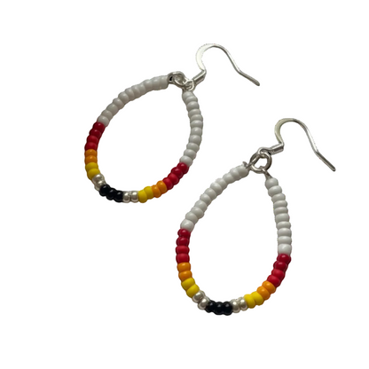 A pair of teardrop-shaped beaded hoop earrings with silver fishhook wires. The hoops are made of small white beads accented with segments of red, orange, yellow, and black beads at the bottom.