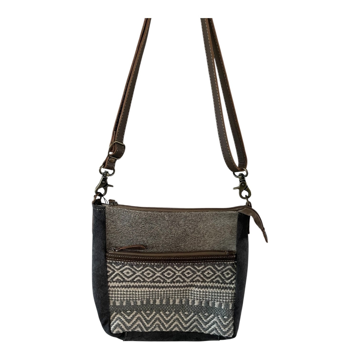 Crossbody bag with patterned flap and brown strap on a white background