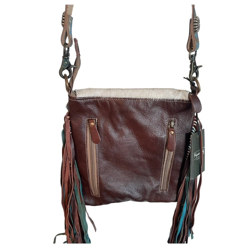 Brown leather bag with fringes and a beige interior on a white background