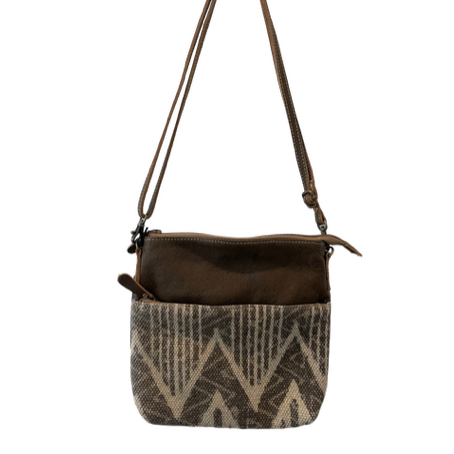 Brown crossbody bag with patterned front pocket on a white background