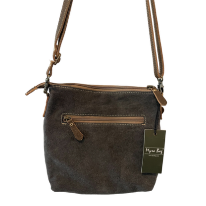 Brown leather handbag with a tag on a white background